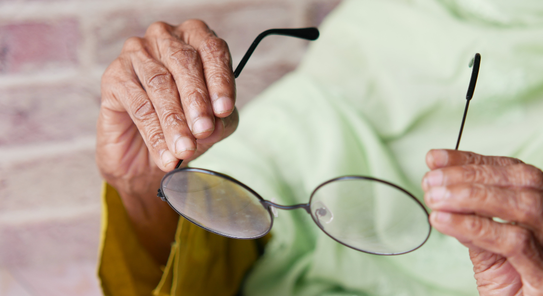 Ældre kvinder holder et par briller.