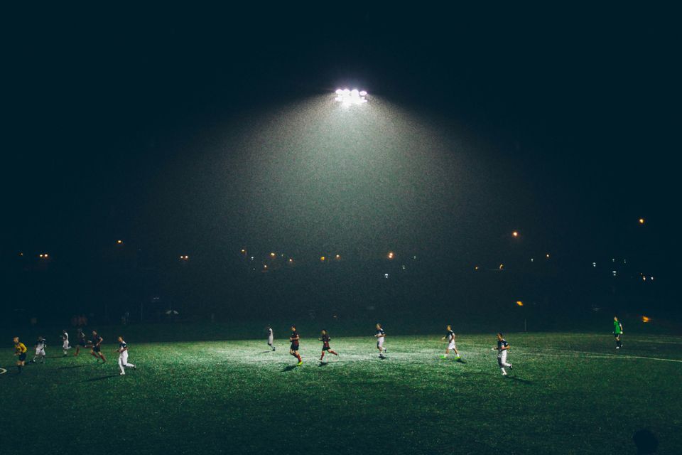 Men playing football in a grass field